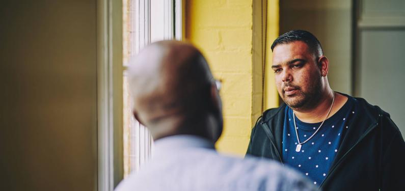 two men talking in a corridor