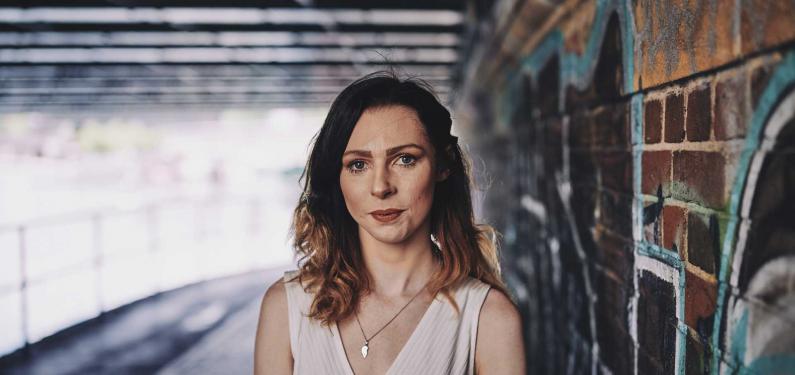 woman standing under a bridge 