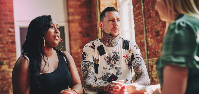 Two women and a man are sitting having a conversation