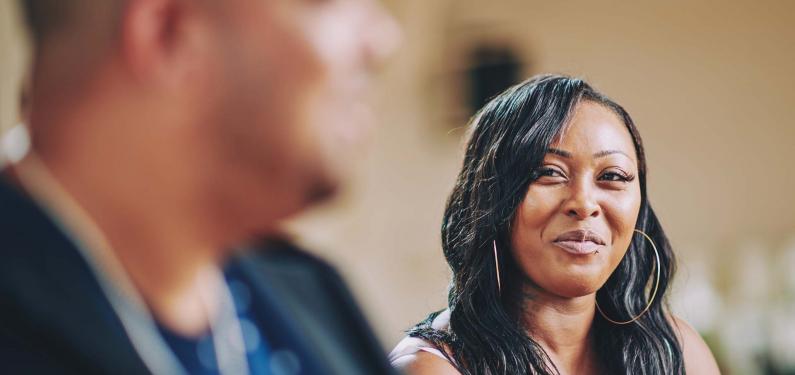 A woman is smiling at a man
