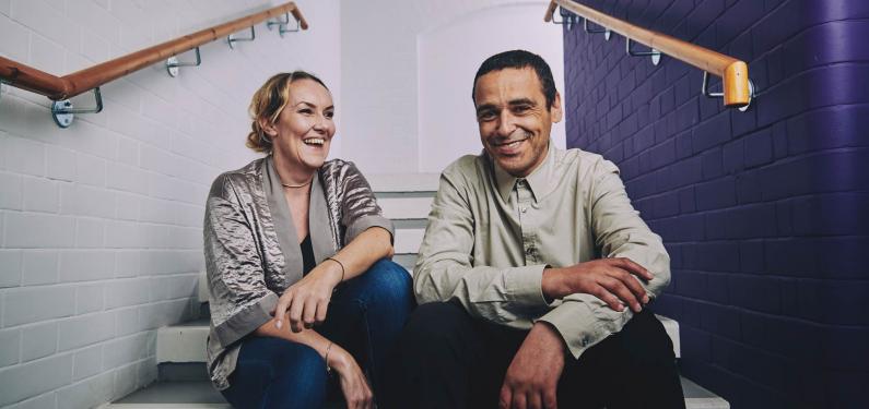 a woman and a man sitting on the stairs laughing