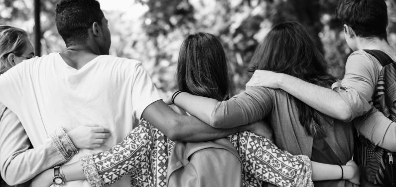 group of young people with arms round each other outside