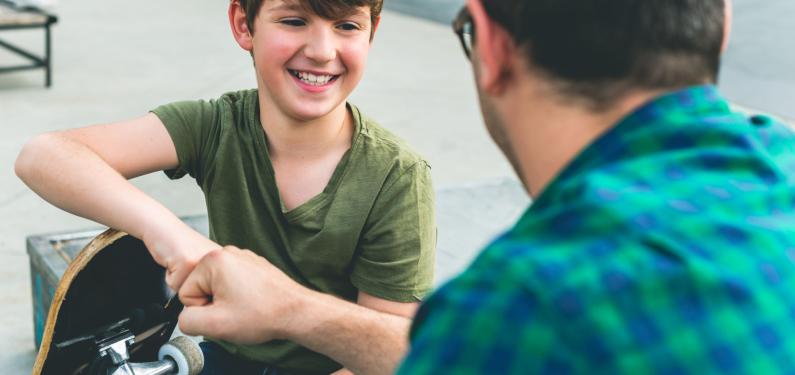 A man and a child at a skatepark