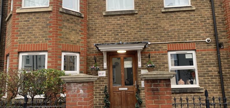 A red brick house with steps leading up to the front door.