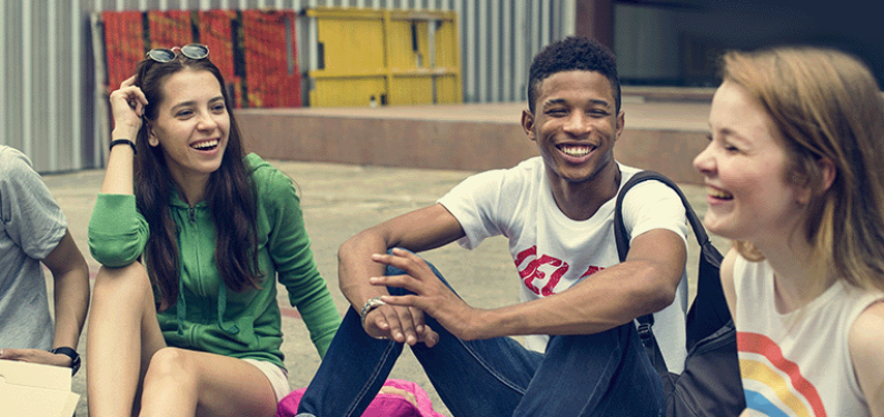 Three young people outside talking and laughing