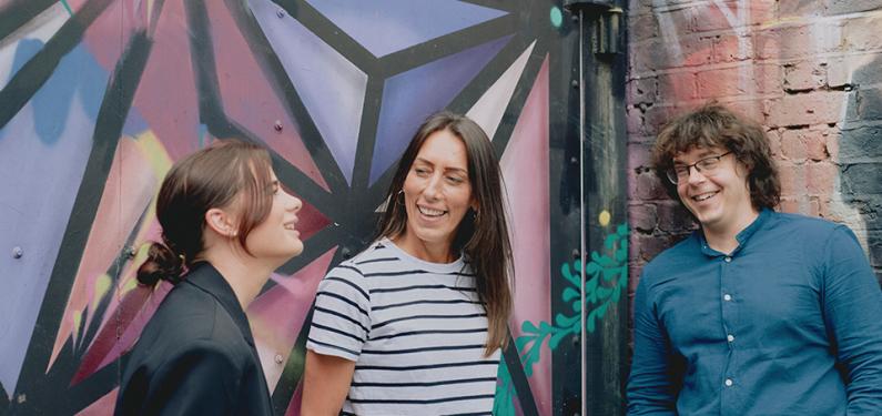 Three people laughing together outside