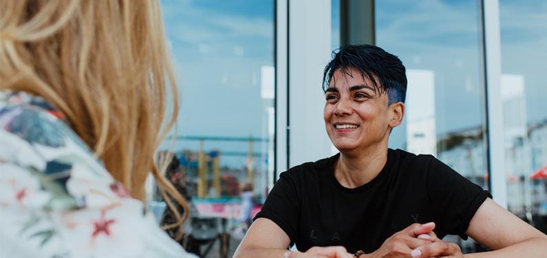 Two people in conversation with one slightly out of focus