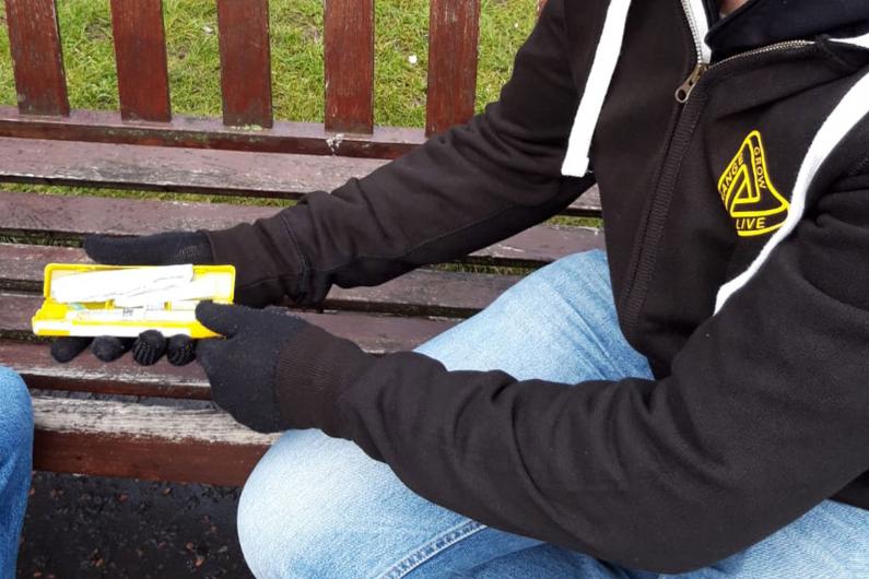 A man showing someone a naloxone kit