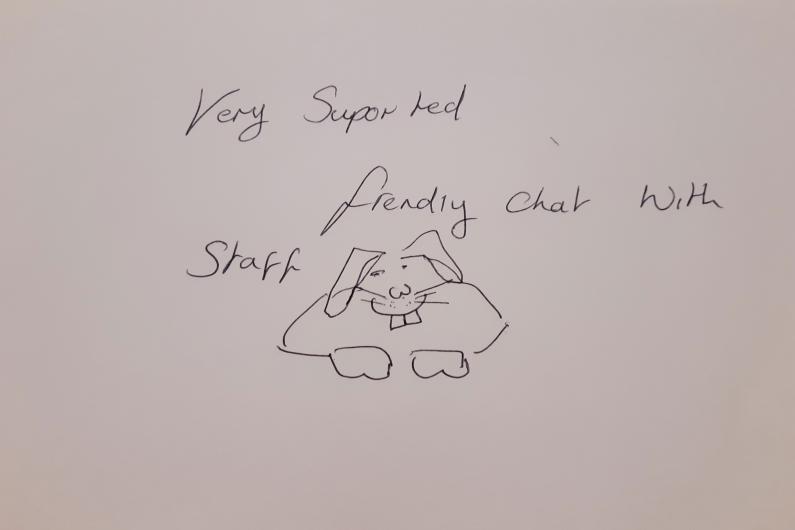 A piece of paper with the words "very supported, friendly chat with staff" and there is a drawing of a bunny rabbit underneath.