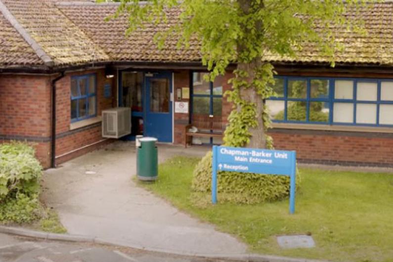 Entrance - the front of a red brick single story building. There is a path leading up to the entrance surrounded by grass