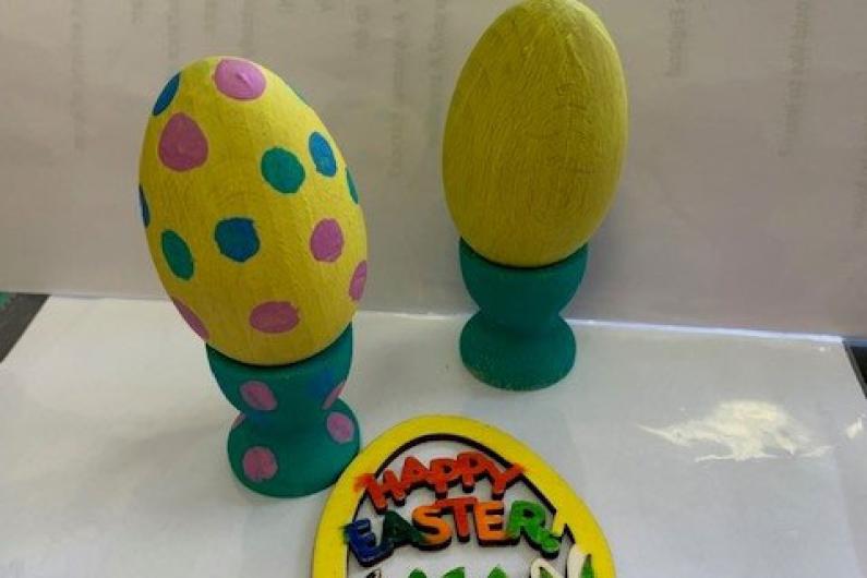 A photo of some wooden eggs that have been painted yellow with colourful polka dots over them and a Happy Easter fridge magnet 