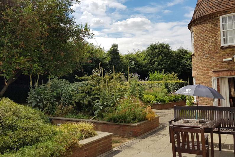 Garden and the side of the building, including hedges and trees