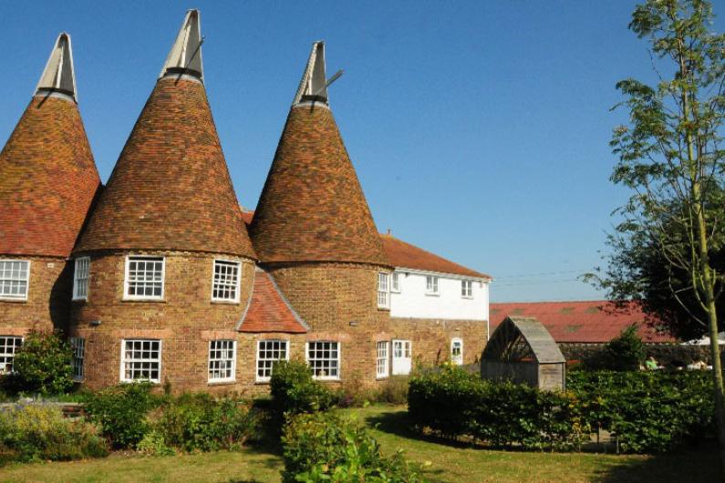 Bridge House - an Oast house - photographed on a sunny day with a clear blue sky