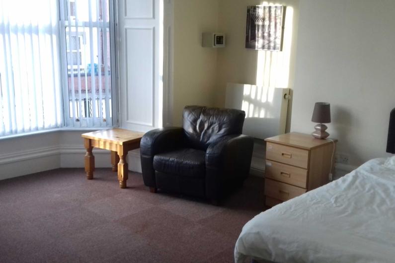 Leigh Bank - Bedroom. Large window, single bed, arm chair and drawers