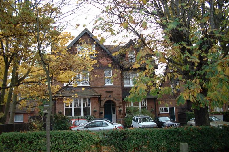 Mount Carmel outside: a large red-bricked building with trees in the foreground