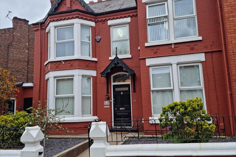 The front of the building - a red-bricked Edwardian building with a black front door and large sash windows