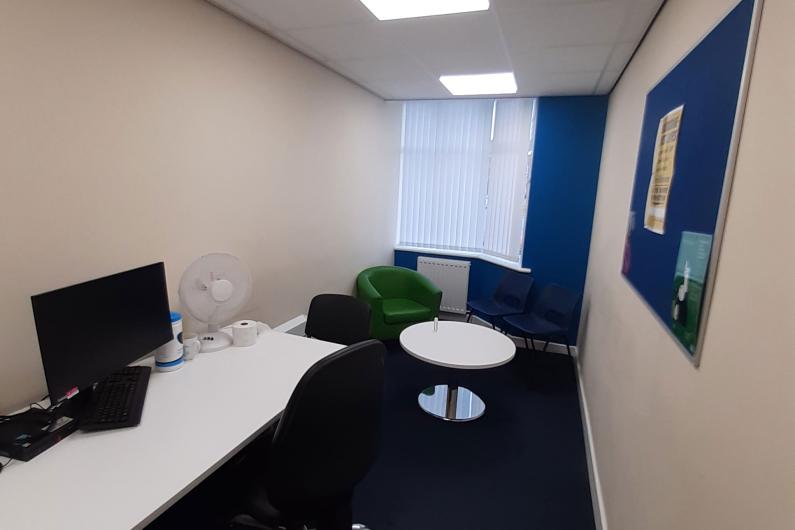 Macclesfield 121 and counselling room - a room with white walls, a computer on a desk, and two chairs around a small circular table