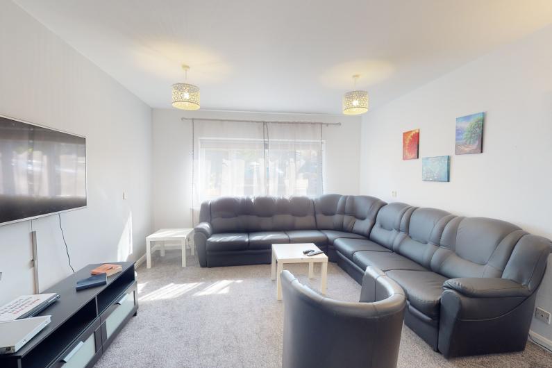 Liberty House Group Room - a bright room with dark sofas white walls.