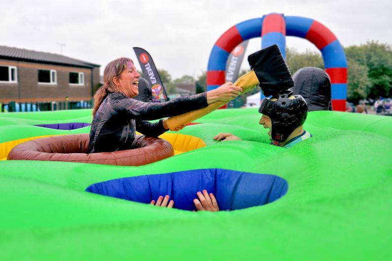 New beginnings - national detox and rehab framework - adults playing a giant human whack a mole game with a novelty hammer