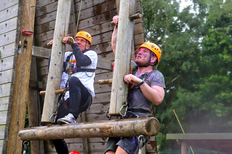 New Beginnings - National detox and rehab framework - two men are climbing an outdoor climbing wall, wearing orange helmets