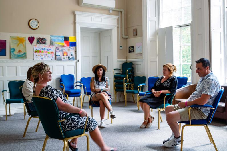 Clouds House - national detox and rehab framework - a study room with people sitting in chairs facing one another for group therapy