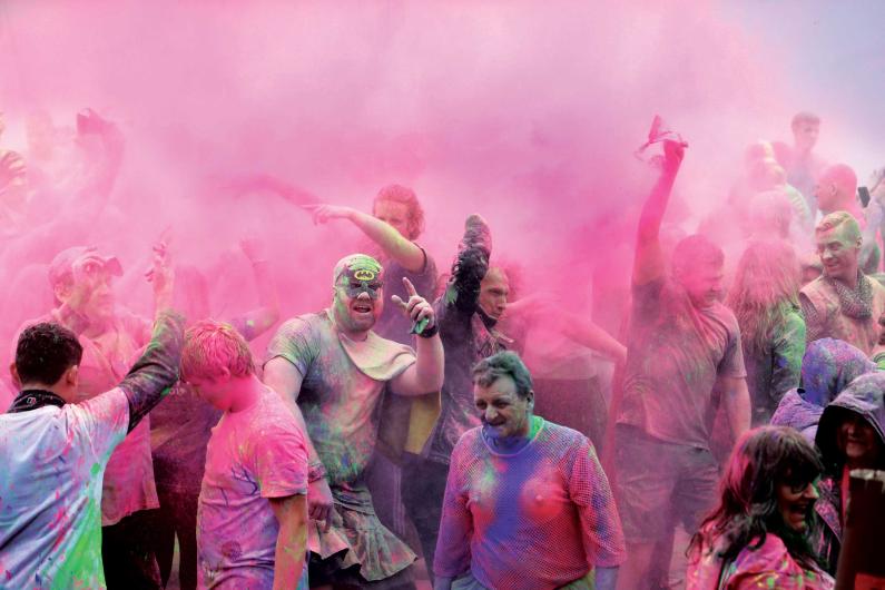 new beginnings - national detox and rehab framework - a group of people are throwing white paint powder around, with a pink dust cloud enveloping them 