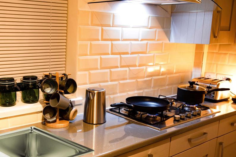  A kitchen with a gas stove top, sink, and toaster on the counters.