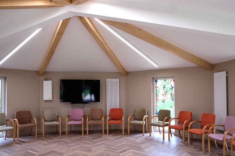 A large open room with chairs lining the edges.