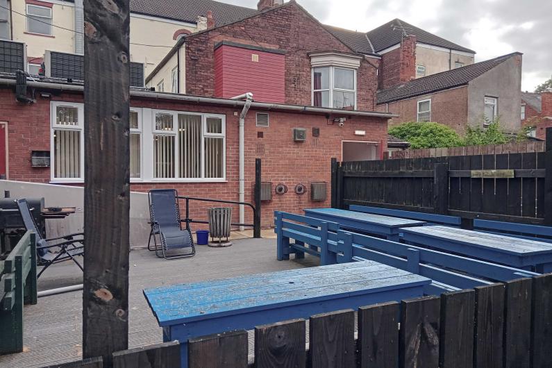 Blue wooden benches in the corner of a garden