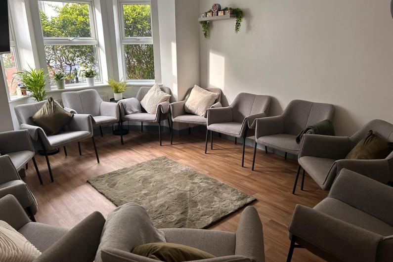 A room with chairs around the edge in a circle