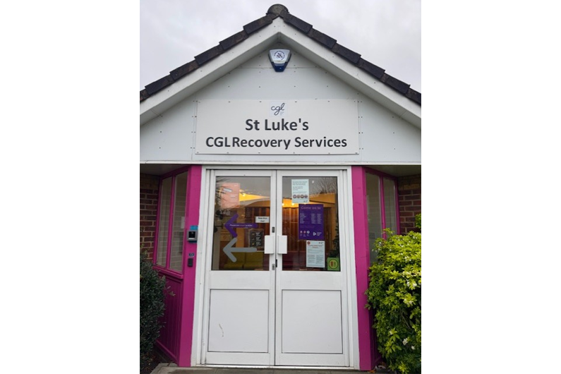 A white door with St Luke's CGL Recovery Service written above and a pointed roof