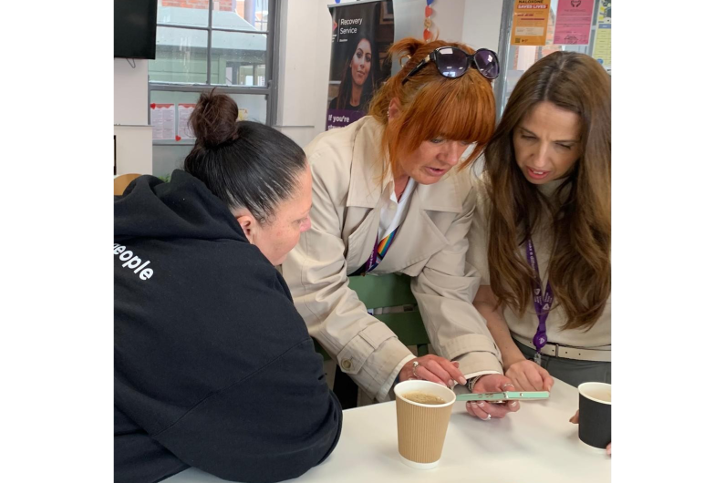 Three women looking at something on a table