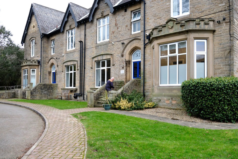 The outside of an old Victorian building with a driveway